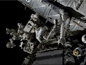 In this photo provided by NASA, Canadian astronaut David Saint-Jacques, center left, works outside the International Space Station, Monday, April 8, 2019. Saint-Jacques and NASA astronaut Anne McClain got an early start Monday morning as they tackled battery and cable work outside the International Space Station. It's the third spacewalk in just 2 ½ weeks for the station crew. (NASA via AP) ORG XMIT: NYCD302