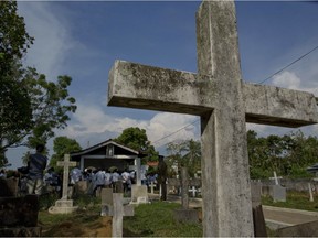 Family members gather at the funeral of an Easter Sunday bomb blast victim at a Methodist cemetery in Negombo, Sri Lanka, Tuesday, April 23, 2019.
