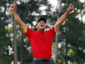 Tiger Woods celebrates after sinking his putt on the 18th green to win the Masters at Augusta National Golf Club on Sunday, April 14, 2019, in Augusta, Ga.