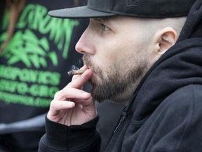 A man smokes a joint at a 4-20 marijuana event in Toronto.