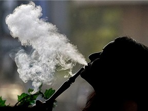 A woman smokes a shisha.