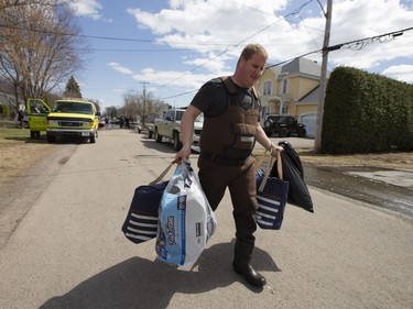 MONTREAL, QUE: April 30, 2019  Resident Patrick Barkley carries possessions from his home on a flooded street in Sainte-Marthe-sur-le-Lac, Quebec April 30, 2019.  (Christinne Muschi / MONTREAL GAZETTE)      ORG XMIT: 62446