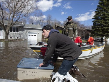 A resident floats some of his possessions after being escorted home by members of the police on a flooded street in Sainte-Marthe-sur-le-Lac, Quebec April 30, 2019.