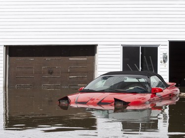 A flooded car sits in front of a home on a flooded street in Sainte-Marthe-sur-le-Lac, Quebec April 30, 2019.