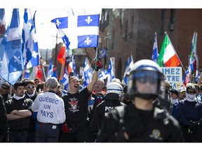 A group of Bill 21 protesters chant outside TVA with riot police watching in Montreal on Saturday, May 4, 2019.