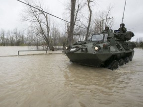 Canadian military personnel use their their TAPV to plow through a flooded street in Rigaud in early May.