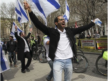 Men dance in front of protesters on Peel St. in Montreal Thursday, May 9, 2019 during Yom Ha'atzmaut celebrations marking Israel Independence Day.