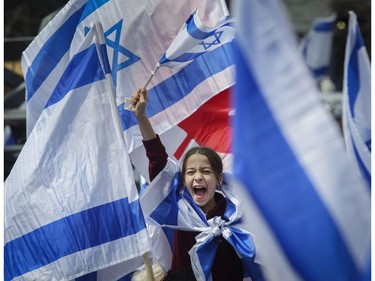 A youngster waves a flag of Israel at Place du Canada in Montreal Thursday, May 9, 2019 during Yom Ha'atzmaut celebrations marking the 71st Israel Independence Day.