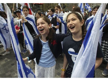 Talia Aspler (left) and Keira Moss sing O Canada at Place du Canada in Montreal Thursday, May 9, 2019 during Yom Ha'atzmaut.