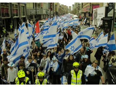 Israel flag wavers dominate the crowds parading from Cabot Square to Place to Canada in Montreal Thursday, May 9, 2019 during Yom Ha'atzmaut celebrations marking the 71st Israel Independence Day.