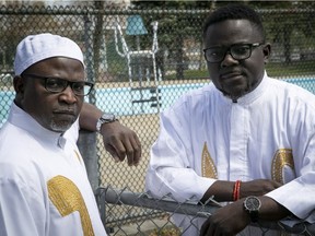 Dressed in the traditional Edo people outfit, Osa Osifo, left, and Pius Ehinoma stand next to a municipal pool on the island of Montreal on Wednesday May 15, 2019.