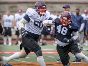 Offensive-lineman Spencer Wilson, left, forces defensive-end Bo Banner wide of the quarterback during Montreal Alouettes training camp practice in Montreal on May 24, 2019.
