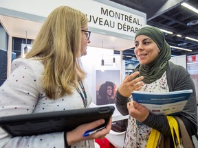 Hanane El Nadjar, right, speaks to the City of Montreal's Laurie Savard during a jobs fair at the Palais des congrès on Wednesday aimed at matching new immigrants with employers.
