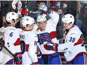 Laval Rocket's Nikita Jevpalovs (11) celebrates his goal with teammates Michael Moravcik (6), Jake Evans (10) and Cale Fleury during first period AHL action in Laval on Oct. 12, 2018.