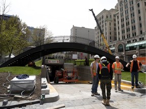 MONTREAL, QUE.: May 22, 2019 -- A partially completed foot bridge crosses over the entrances to underground parking in Dorchester Square in Montreal, on Wednesday, May 22, 2019.