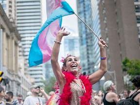 Tanaz Mehraban dances with the transgender flag during at the annual Pride Festival parade, July 3, 2016, in Toronto.