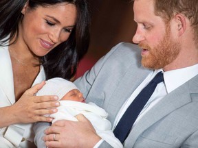 Britain's Prince Harry, Duke of Sussex (R), and his wife Meghan, Duchess of Sussex, pose for a photo with their newborn baby son in St George's Hall at Windsor Castle in Windsor, west of London on May 8, 2019.