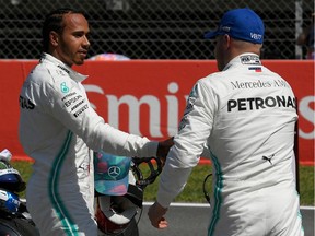 Mercedes' British driver Lewis Hamilton (L) congratulates Mercedes' Finnish driver Valtteri Bottas after he secured the pole position following the qualifying session at the Circuit de Catalunya in Montmelo in the outskirts of Barcelona on May 11, 2019 ahead of the Spanish Formula One Grand Prix.