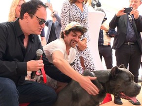 US film director Quentin Tarantino poses with stand-in hound Haru as he attends the Palm Dog on the sidelines of the 72nd edition of the Cannes Film Festival in Cannes, southern France, on May 24, 2019.