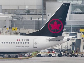 An Air Canada Boeing 737 Max 8 aircraft is shown next to a gate at Trudeau Airport in Montreal on March 13, 2019. Air Canada says it is removing its grounded Boeing 737 Max jets from service until at least Aug. 1 in order to provide more certainty for passengers with summer travel plans.