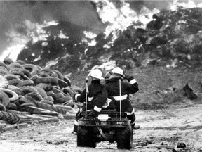 Firefighters in an all-terrain vehicle patrol a tire dump outside St-Amable during a fire there in May 1990. This photo was published in the Montreal Gazette on May 18, 1990.