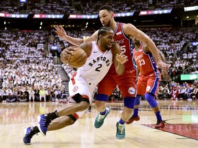 Philadelphia 76ers guard Ben Simmons (25) defends as Toronto Raptors forward Kawhi Leonard (2) drives to the net during second half NBA Eastern Conference semifinal action in Toronto on Sunday, May 12, 2019.