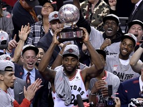 Toronto Raptors forward Kawhi Leonard (2) holds up the trophy after the team's 100-94 game six win over the Milwaukee Bucks to become the NBA Eastern Conference champions, in Toronto on Saturday, May 25, 2019.