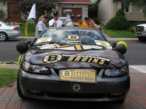 Pat Leonard, far left, Wade Wilson, centre, holding Stanley Cup replica, and their friends from Greenfield Park celebrated the Boston Bruins' Stanley Cup victory by driving Leonard's car in the city's 2011 Canada Day Parade. Credit: Courtesy of Wade Wilson