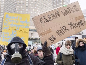 People hold up signs demanding action on climate change during a demonstration in Montreal, Saturday, December 8, 2018.