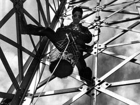 Photo dated May 15, 1948: John Flynn Jr. clutches a basket of lightbulbs. The 240 light bulbs on the cross on Mount Royal were changed three or four times a year.