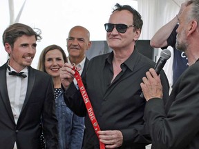 Director Quentin Tarantino poses with the Palm Dog collar awarded to Brandy, the dog that appeared in 'Once Upon a Time in Hollywood' at the 72nd international film festival, Cannes, on Friday, May 24, 2019.
