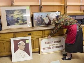 A member of the Sisters of Sainte-Anne adjusts some items during a sale at a convent in Montreal, Sunday, May 19, 2019.