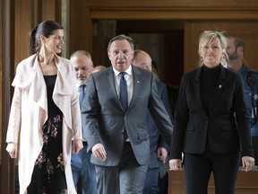 Quebec Premier Francois Legault, flanked by Quebec Deputy premier and Public Security Minister Genevieve Guilbault, left, and Quebec Municipal Affairs and Housing Minister Andree Laforest walks to a news conference to announces an action plan on floods, Wednesday, May 1, 2019 at the legislature in Quebec City.