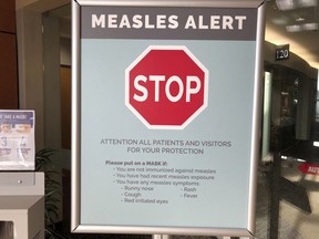 A sign warning patients and visitors of a measles outbreak is shown posted at a clinic in Vancouver, Wash.