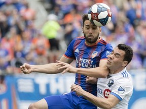 FC Cincinnati defender Mathieu Deplagne (17) heads the ball over Montreal Impact defender Daniel Lovitz (3) during an MLS soccer match on Saturday, May 11, 2019, in Cincinnati, Ohio.