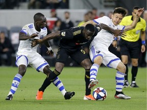 Los Angeles FC forward Adama Diomande, center, vies against Montreal Impact midfielders Ken Krolicki, right, and Micheal Azira (32) during the second half of an MLS soccer match in Los Angeles, Friday, May 24, 2019. LAFC won 4-2.