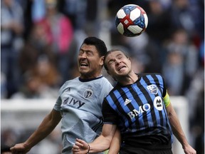 Sporting Kansas City midfielder Roger Espinoza, left, and Montreal Impact midfielder Samuel Piette, right, head the ball during the first half of an MLS soccer match in Kansas City on March 30, 2019.