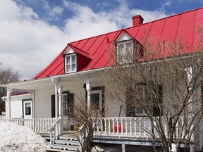 The red roof, green window frames and white cladding make up a traditional colour scheme for this Quebecois style house, built in 1835.