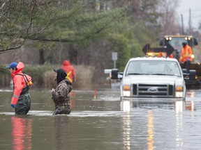 Volunteer emergency workers check on homes surrounded by floodwaters on Ile Bizard west of Montreal, Saturday, April 27, 2019.