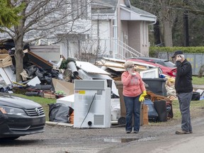 Residents clean up after the floodwaters recede in certain sectors on Thursday, May 2, 2019, in Ste-Marthe-sur-le-Lac. A dike broke last week causing widespread flooding and forcing thousands of people to evacuate.