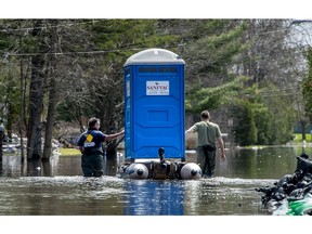 Residents of Joly St. on Île-Bizard float a porta-potty down their street on Saturday, May 4, 2019. Residents of the street have not been evacuated, but cannot flush their toilets.