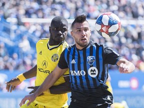 Montreal Impact's Saphir Taider, right, and Columbus Crew SC's Jonathan Mensah keep their eyes on the ball during first half MLS soccer action in Montreal on April 13, 2019.