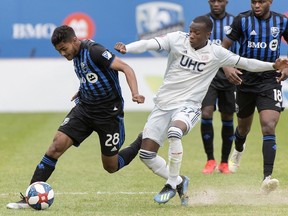 Montreal Impact's Shamit Shome, left, is challenged by New England Revolution's Luis Caicedo during second half action in Montreal on May 18, 2019.