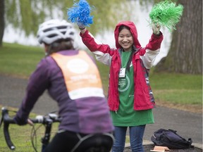 Tour de l'Ile volunteer Kayla Ho cheers on cyclists as they make their way onto René-Lévesque Park in Lachine on Sunday June 2, 2019.