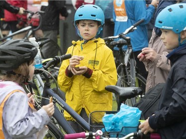 Tour de l'Ile participant Emile Jarry, centre, shares some cookies with his sister Victoria and brother Oscar as they take a small break in René-Lévesque Park in Lachine on Sunday June 2, 2019.