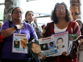 Women hold signs during the closing ceremony of the National Inquiry into Missing and Murdered Indigenous Women and Girls in Gatineau on Monday, June 3, 2019.