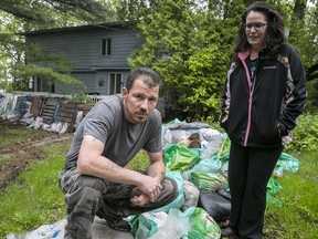 Joanna and Jason Lemieux, with some of the sand bags that saved their home from flooding in Île-Bizard.