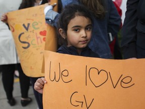 Carina D'Amore holds a sign during a June 5 rally to save General Vanier elementary school from being transferred to the French sector.