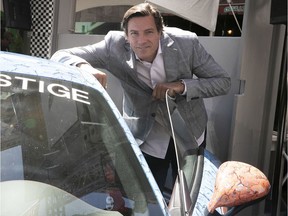 Former Canadien Patrice Brisebois gets a look at race cars on Peel St. ahead of Sunday's Canadian Grand Prix at Circuit Gilles-Villeneuve.