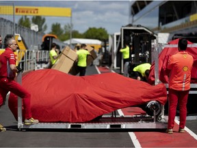 Ferrari crew members wait for the garage to clear to move Charles Leclerc's car as teams begin to set up for the Canadian Grand Prix in Montreal, on Tuesday, June 4, 2019.